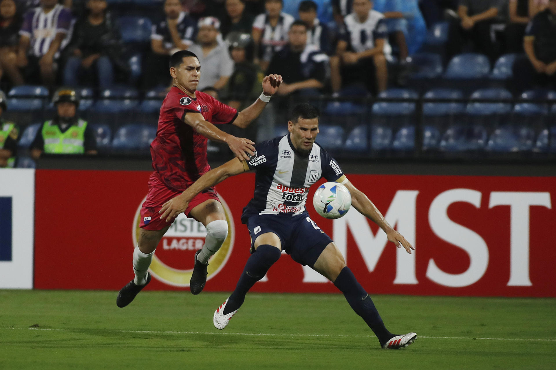 Guillermo Enrique (d), de Alianza Lima, en un mano a mano con Gustavo Caballero, de Nacional en un partido de la primera ronda de la Copa Libertadores en el estadio Alejandro Villanueva en Perú. EFE/ Martín Fonseca
