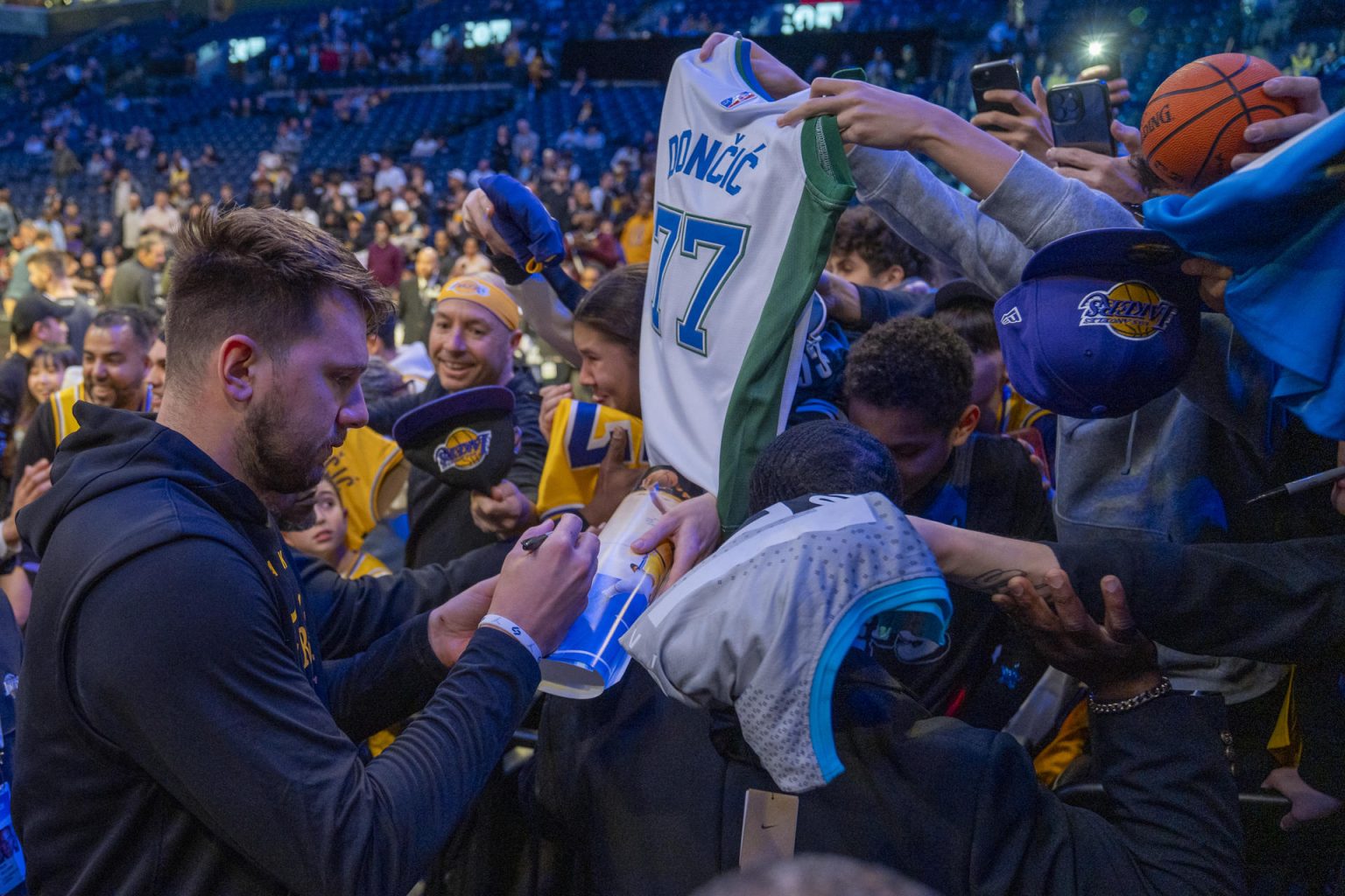 Luka Doncic de Los Angeles Lakers firma autógrafos antes del partido contra los Brooklyn Nets. EFE/ Angel Colmenares