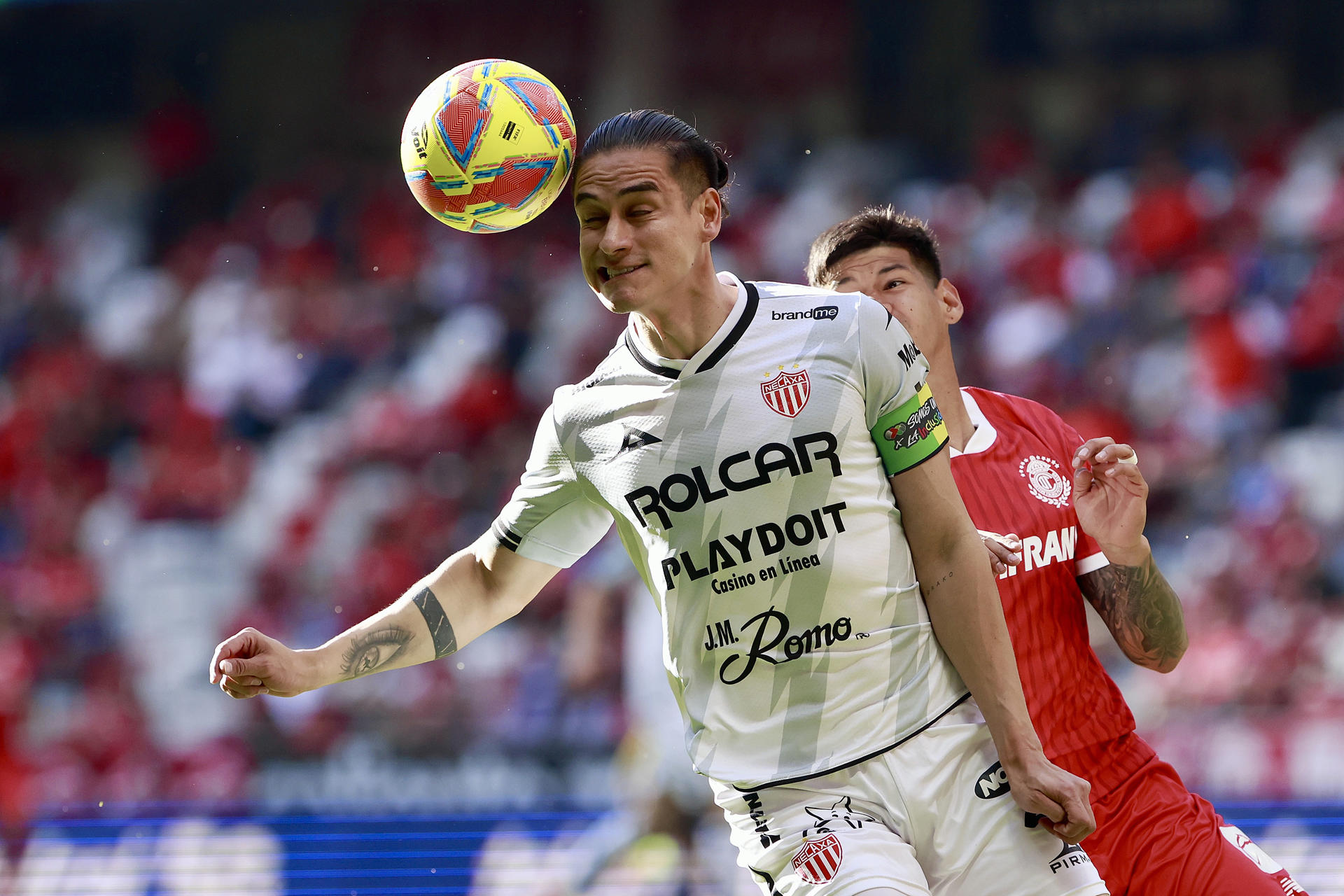 Robert Morales (atrás) del Toluca presiona a Alexis Peña (frente) del Necaxa este sábado en partido de la undécima jornada del torneo Clausura mexicano en el estadio Nemesio Diez, de Toluca. EFE/ Alex Cruz
