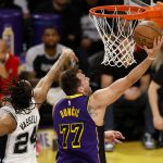 El jugador de los Los Angeles Lakers, Luka Doncic (D), entra a canasta tras superar al jugador de los San Antonio Spurs, Devin Vassell (I), durante el segundo cuarto del partido disputado en el Crypto.com de Los Ángeles. EFE/EPA/CAROLINE BREHMAN