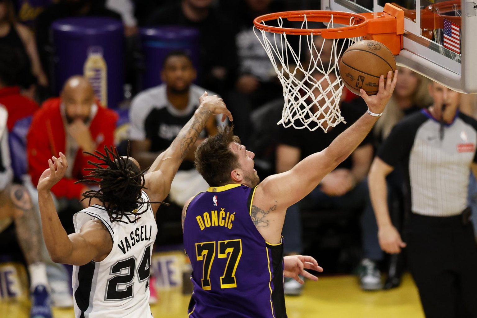 El jugador de los Los Angeles Lakers, Luka Doncic (D), entra a canasta tras superar al jugador de los San Antonio Spurs, Devin Vassell (I), durante el segundo cuarto del partido disputado en el Crypto.com de Los Ángeles. EFE/EPA/CAROLINE BREHMAN