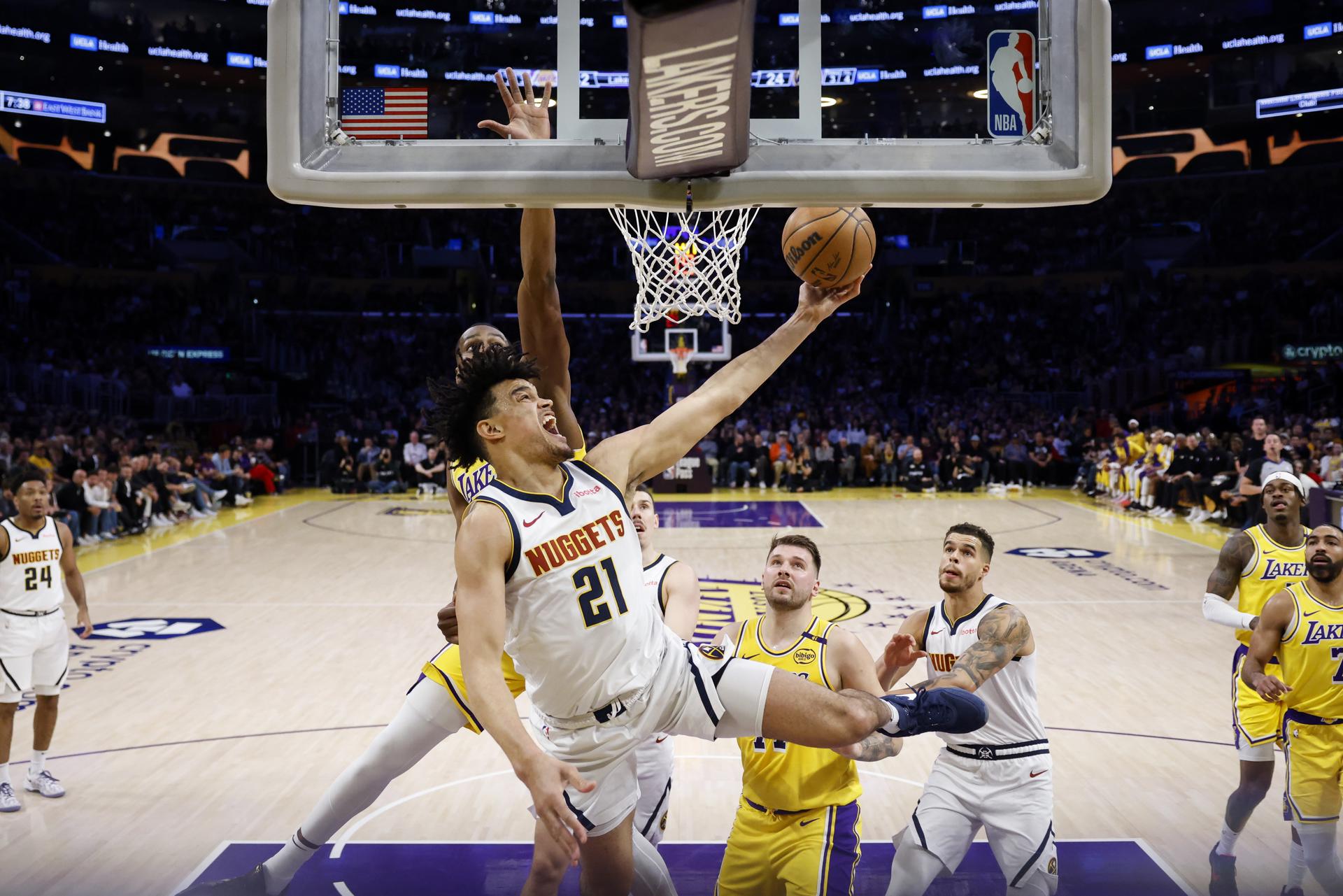 El ala-pívot de los Denver Nuggets, Spencer Jones (frente) avanza al aro con el balón ante la presión del pívot de Los Angeles Lakers, Christian Koloko (de espalda) durante el partido jugado este jueves en Los Ángeles. EFE/EPA/CAROLINE BREHMAN
