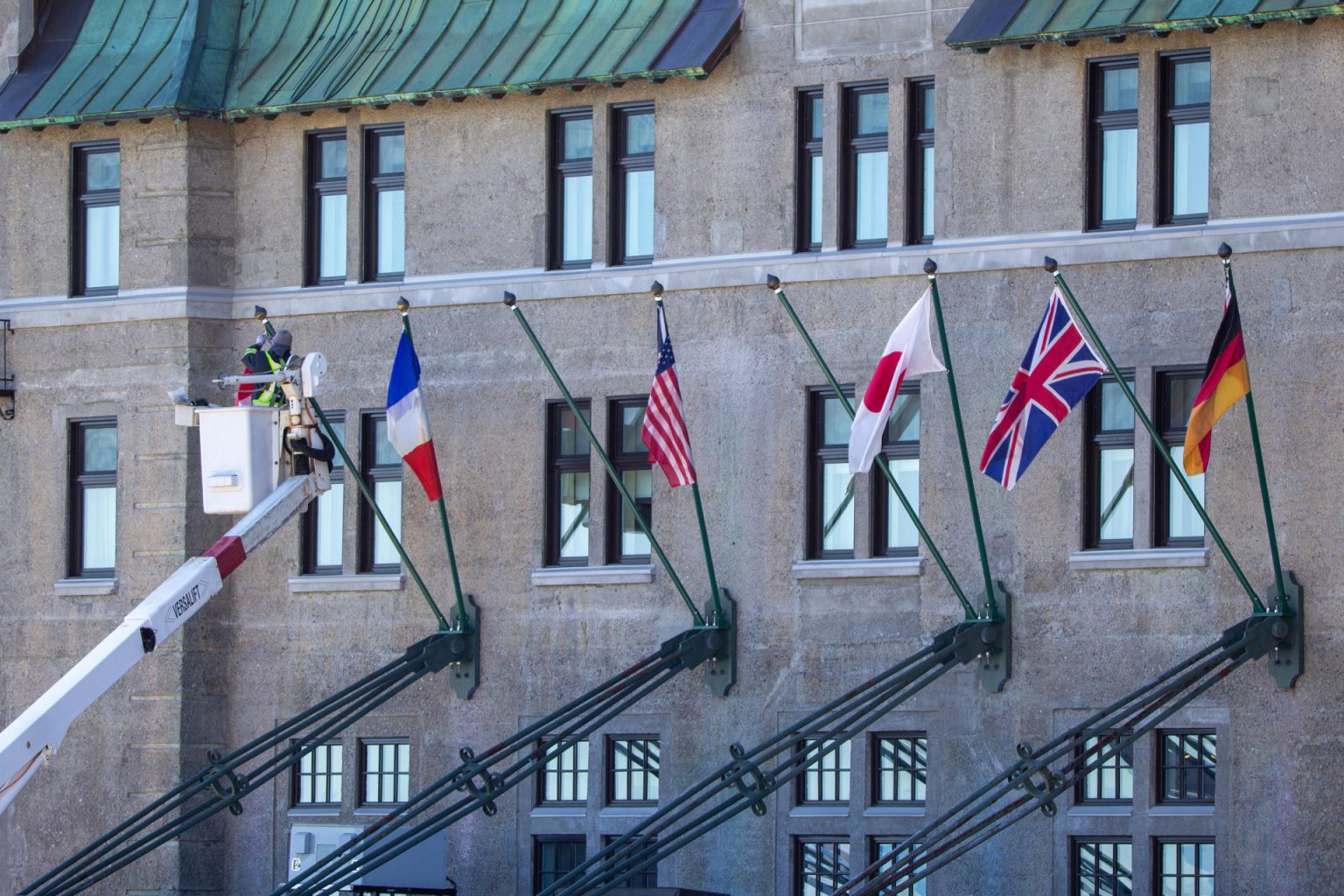 Un trabajador instala las banderas de los países de los ministros de Exteriores del G7 este miércoles, en la fachada de hotel en Charlevoix (Canadá).  EFE/ Julio César Rivas