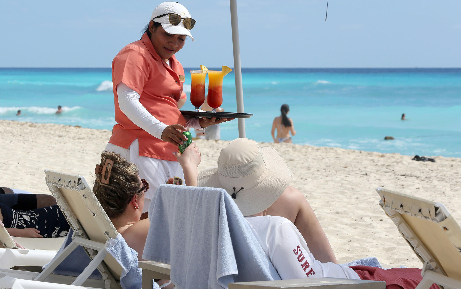 Personal de complejos hoteleros atienden a turistas en una playa del balneario de Cancún este jueves, en Quintana Roo (México). EFE/ Alonso Cupul
