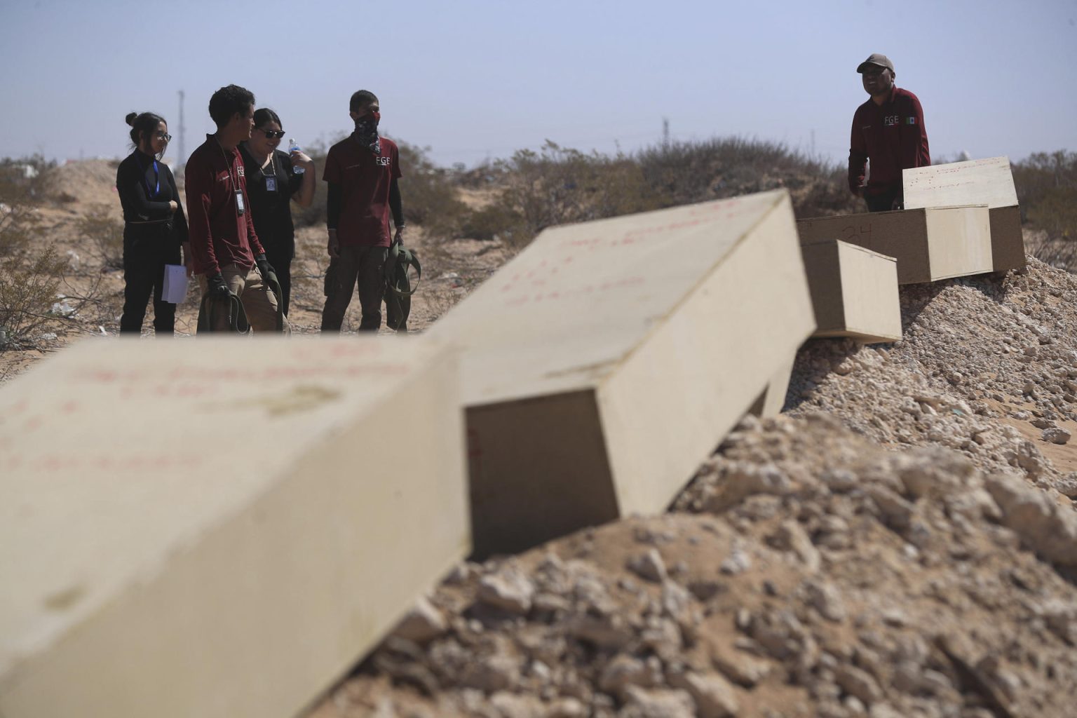 Trabajadores de la Fiscalía realizan una inhumación en una fosa común este viernes, en Ciudad Juárez (México). EFE/ Luis Torres