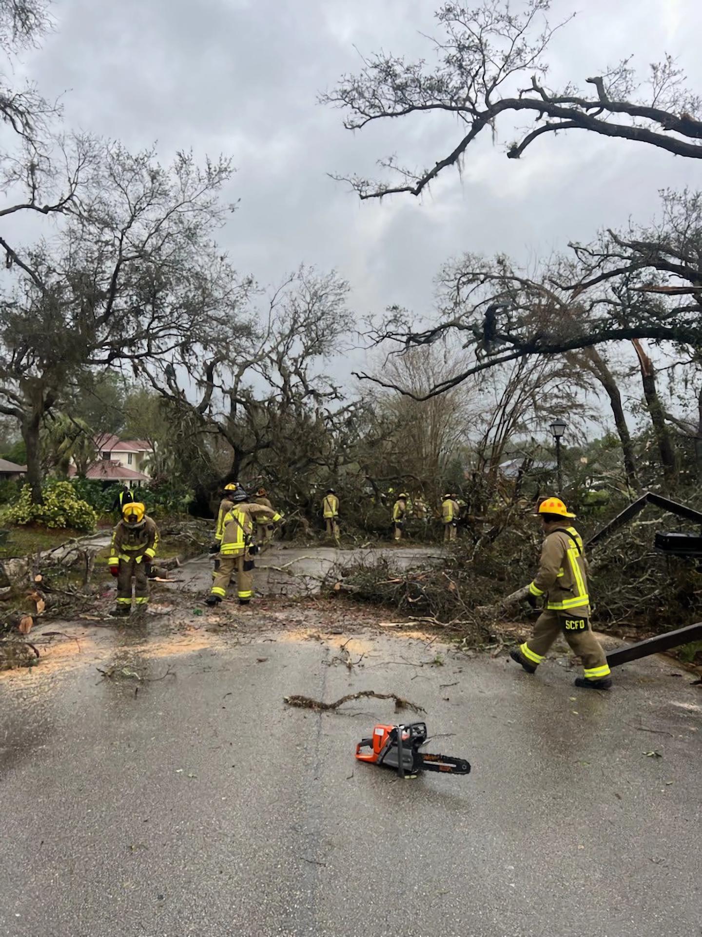 Fotografía cedida por el Departamento de Bomberos del Condado Seminole donde aparece unos agentes mientras retiran los escombros y arbustos de una carretera este lunes en Longwood, Florida. EFE/Bomberos del Condado Seminole /SOLO USO EDITORIAL /NO VENTAS /SOLO DISPONIBLE PARA ILUSTRAR LA NOTICIA QUE ACOMPAÑA /CRÉDITO OBLIGATORIO
